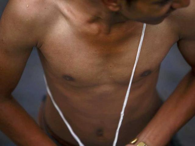 A Hindu devotee wears a new sacred thread after changing it during the Janai Purnima (sacred thread festival) at the Pashupatinath temple in Kathmandu. (Reuters)