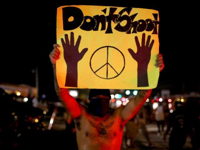 Demonstrators face off against the police as they are cleared from the street while protesting the shooting death of Michael Brown. (AFP Photo)