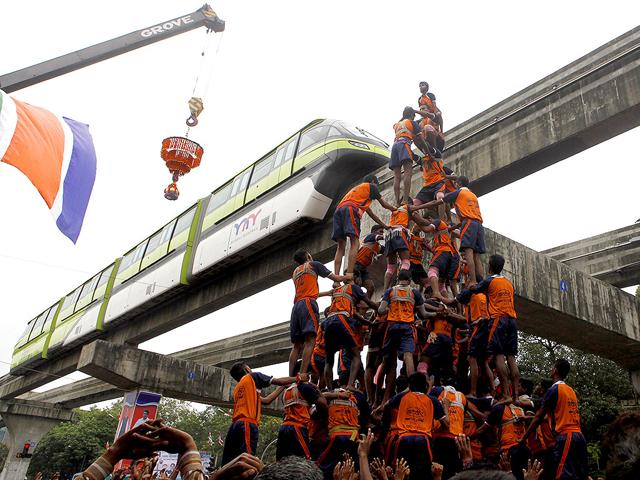 Youth form a human pyramid to break the "dahi handi" to mark Janmashtami celebrations as monorail passes through Chembur in Mumbai. (Kunal Patil/HT Photo)