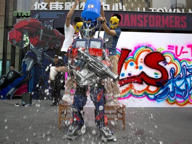 A man dressed as Optimus Prime, a character from the Transformers movies takes the "Ice Bucket Challenge" to raise awareness for the disease ALS in Beijing. (AP Photo)