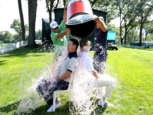 Golfers Justin Rose of England and Brandt Snedeker of the USA take the 'ice bucket challenge' with a bit of help from their caddies Mark Fulcher and Scott Vale. (AFP Photo)