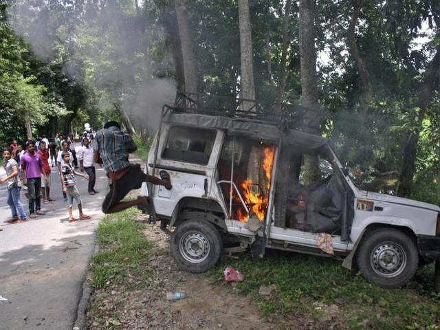 A demonstrator kicks a vehicle that was set on fire during a protest at Golaghat district in the northeastern Indian state of Assam. (Reuters Photo)