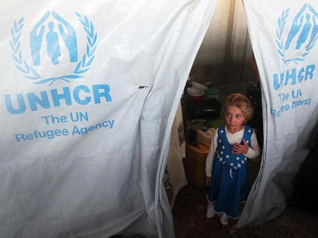 A young displaced Iraqi Shiite, who fled her homes a few weeks ago, due to attacks by Islamic State (IS) jihadists in the northern city of Mosul, looks out from inside a tent at the Bhrka camp ten kilometers west of Arbil, the capital of northern Iraq's Kurdistan autonomous region. (AFP Photo)