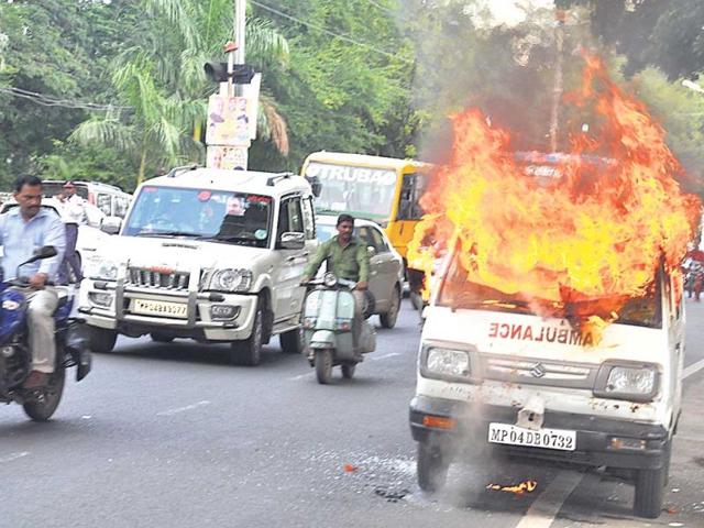 Firemen douse the fire in an ambulance, in Bhopal on Monday. (Praveen Bajpai/HT photo)