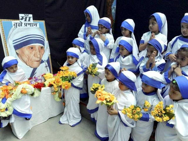 Children dressed as Mother Teresa offer prayers on the occaision of her birth anniversary, in Bhopal on Tuesday. (PTI photo)