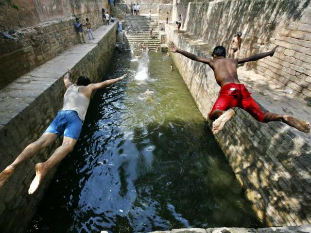 Boys jump into a Baoli (step-well) called Gandhak Ki Baoli in Mehrauli, Delhi. (Arun Sharma/HT Photo)