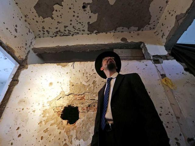 Rabbi Moshe Gourarie from New Jersey looks at a wall riddled with bullet marks from the 2008 terror attack at the Chabad Centre, during the reopening of the Jewish centre in Mumbai. (AP Photo)