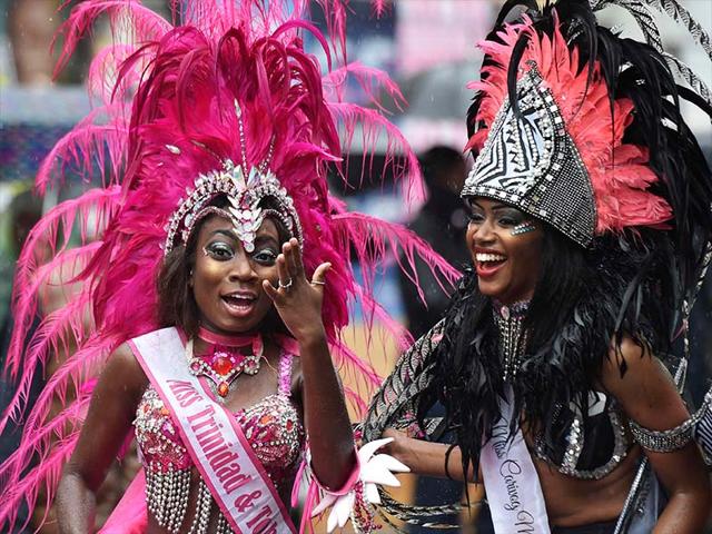 Revellers react during the rain at the Notting Hill Carnival in west London August 25, 2014.. The Notting Hill Carnival honours London's Afro-Caribbean culture in an area which was home to thousands of immigrants to Britain from the Caribbean in the 1950s onwards.(REUTERS/Toby Melville)