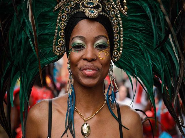 A performer wears an ornate head dress during the parade on the second day of the Notting Hill Carnival in west London on August 25, 2014.(AFP photo/Leon Neal)