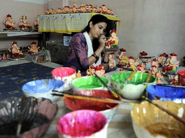 A woman gives finishing touches to Ganesh idols in Indore as the city gears up to celebrate Ganesh Chaturthi. (Arun Mondhe/HT photo)