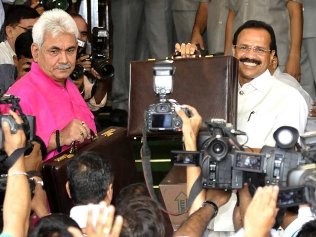 Railway Minister DV Sadananda Gowda (L) and Minister of State for Railway Manoj Singha hold up their briefcases at Parliament before presenting the railway budget at Parliament House Gate No.1, in New Delhi. (Sonu Mehta/HT Photo)