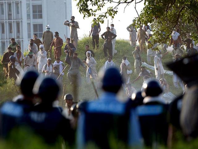 Pakistani supporters of opposition politician Imran Khan and Canada-based Pakistani cleric Tahir-ul-Qadri during clashes near Pakistan Prime Minister Nawaz Sharif's residence in Islamabad on Sunday. (AFP PHOTO)