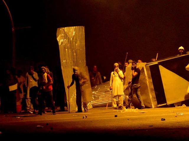 Imran Khan and Tahir ul Qadri's supporters block a street during clashes with security forces near Nawaz Sharif's residence in Islamabad on Sunday. (AFP PHOTO)