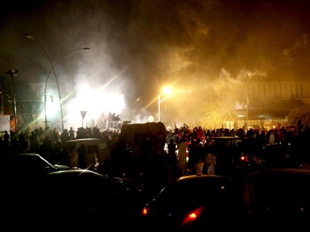 Pakistani police fire tear gas shell to disperse protesters during clashes in Islamabad on Sunday. Pakistani police charged with batons and fired tear gas and rubber bullets at thousands of protesters marching toward Nawaz Sharif's official residence and the adjacent parliament building in Islamabad on Saturday. (AP Photo)