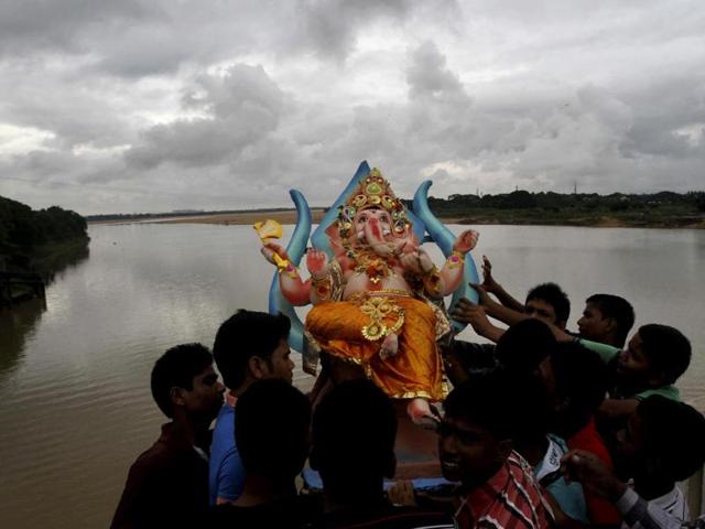 Devotees prepare to immerse an idol of Lord Ganesha into river Kuakhai after worshiping it during the Ganesh Chaturti festival on the outskirts of Bhubaneswar. (AP Photo)