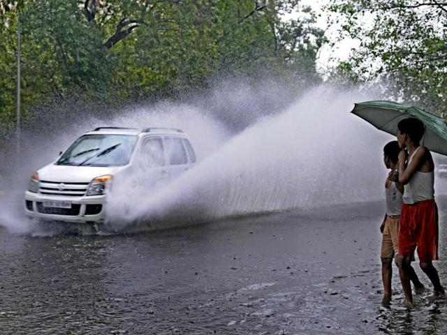 A car makes it way through waterlogged road during heavy rain at Tolstoy Marg, Connaught Place, New Delhi. (Sonu Mehta/HT Photo)