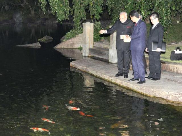 PM Narendra Modi (L) and Japanese Prime Minister Shinzo Abe (C) feed fish at the State Guest House in Kyoto. (AFP Photo)