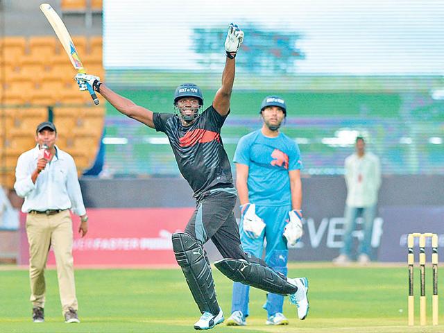 Bolt celebrates after his team won the four-over exhibition match against Yuvraj Singh's team. (AFP/Manjunath Kiran)