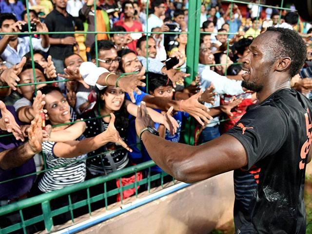 Olympic Gold Medalist sprinter Usain Bolt greets fans during a friendly cricket match. (PTI/Shailendra Bhojak)