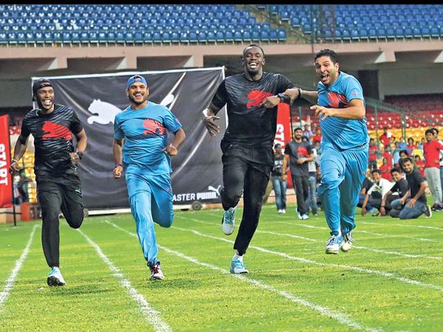 Yuvraj Singh jokingly pushes Usain Bolt to win the 100-meter friendly race. (AP Photo/Aijaz Rahi)