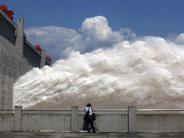 China, Yichang: September 3, 2014 A man takes pictures of floodwater released from the Three Gorges Dam, a gigantic hydropower project on the Yangtze river, in Yichang, central China's Hubei province, after heavy downpours in the upper reaches of the dam caused the highest flood peak of the year. (AFP)