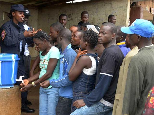 Dolo-s-Town-residents-wait-cleaning-their-hands-with-a-sanitiser-during-an-information-meeting-at-Dolo-s-Town-some-60-km-east-of-Monrovia-quarantined-as-a-measure-to-contain-the-spread-of-Ebola-AFP-Photo