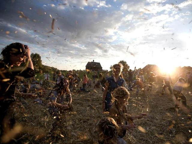 People dance and throw straw during a traditionnal festival in village Ozerco, some 10 km from Minsk. (AFP Photo)