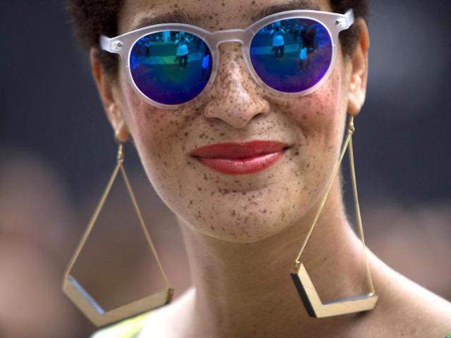 A fashionista wearing sunglasses smiles as she walks around Lincoln Center during New York Fashion Week in the Manhattan borough of New York. (Reuters Photo)