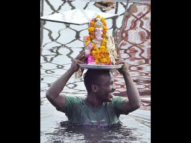 A devotee carries Lord Ganesh's idol for immersion at Yamuna Ghat in New Delhi on Monday. (Sonu Mehta/ HT Photo)