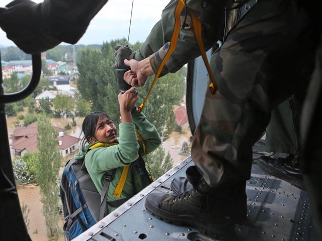 People-crossing-through-the-water-channel-in-Mehjoor-Nagar-area-which-was-submerged-in-8-feet-of-water-during-the-floods-in-Jammu-and-Kashmir-Nitin-Kanotra-HT-Photo