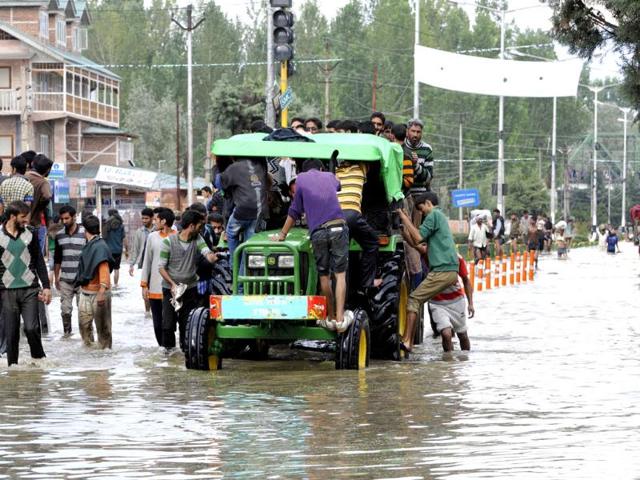 A tractor rescuing stranded people in Srinagar. (Nitin Kanotra/HT Photo)