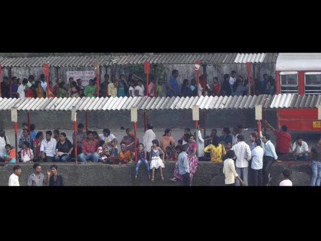 Devotees wait at the bus stop as the Mount Mary fair begins in Bandra, Mumbai. (Vidya Subramanian/HT photo)