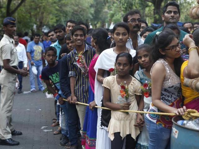 Devotees wait at the bus stop as the Mount Mary fair begins in Bandra, Mumbai. (Vidya Subramanian/HT photo)