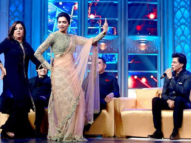Director Farah Khan along with Deepika Padukone performs as actor Shah Rukh Khan watches during a music launch of their upcoming film Happy New Year in Mumbai. (AP Photo)