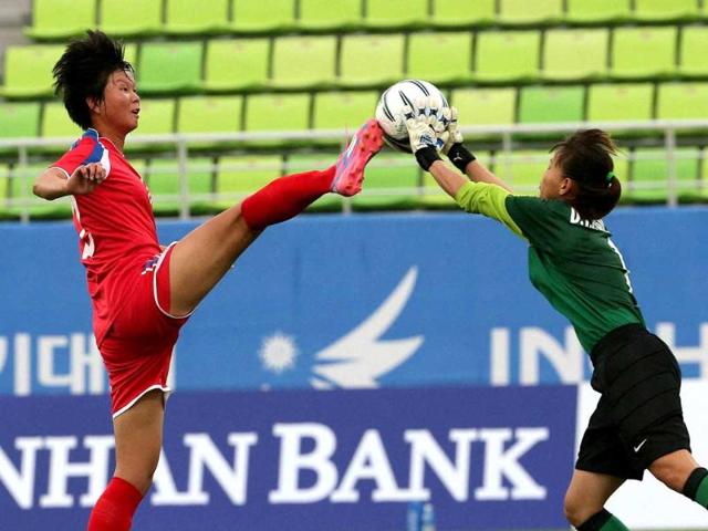 North Korea's Yunmi Kim attempts to kick the ball from Vietnam goalkeeper Thi Kieu Trinh Dang during their women's first round group C soccer match at the 17th Asian Games in Incheon, South Korea. (AP Photo)