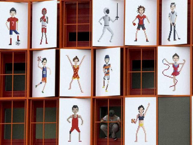 A man looks out of framed images of athletes decorated for the 17th Asian Games in Incheon, west of Seoul, South Korea. (AP Photo)