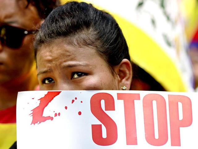 A Tibetan girl holds a placard in protest against China's President Xi Jinping's three-day visit to Indiaat Majnu ka Tilla road in New Delhi on Wednesday. (Arun Sharma/HT Photo)
