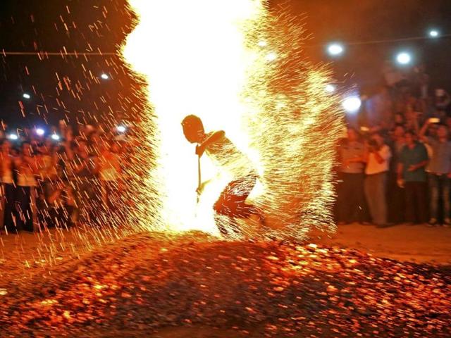 A man runs through burning charcoal barefooted as he participates in a traditional ritual called "Lianhuo", or "fire walking", in Pan'an county, Zhejiang province. (Reuters Photo)
