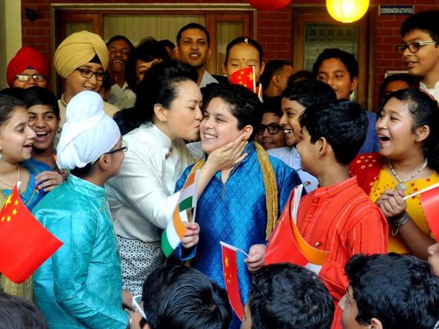 The wife of Chinese President Xi Jinping, Peng Liyuan, greets a child from the Tagore School as she arrives for a visit in New Delhi. (HT Photo)