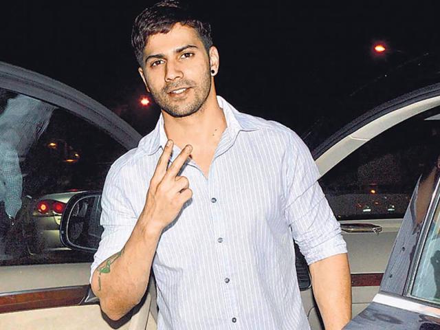Varun Dhawan displayed a victory sign to the photographers outside a Bandra eatery. (HT Photo/Yogen Shah)