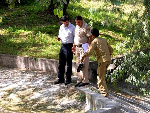 The police and zoo personnel retrieve the shoes of the schoolboy who was attacked by the white tiger at the Delhi Zoo on Tuesday. (AFP Photo)