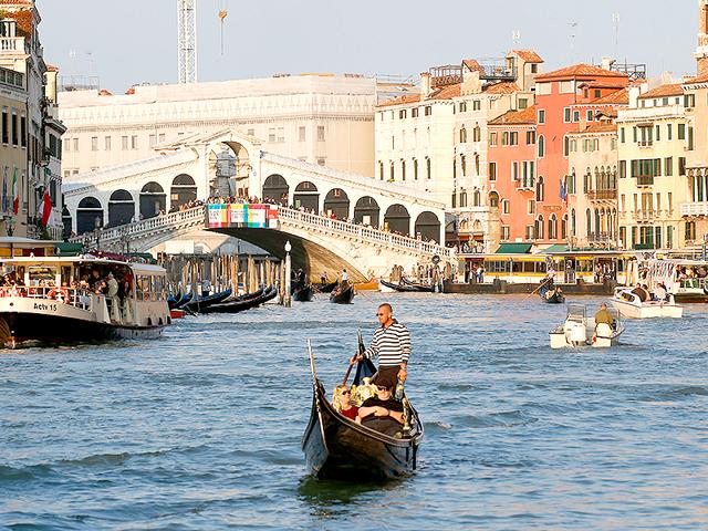 Boats sails past the Rialto bridge in Venice, Italy. Venice city officials are closing a walkway fronting the picturesque Grand Canal on Monday to keep crowds away from George Clooney's wedding. (AP)