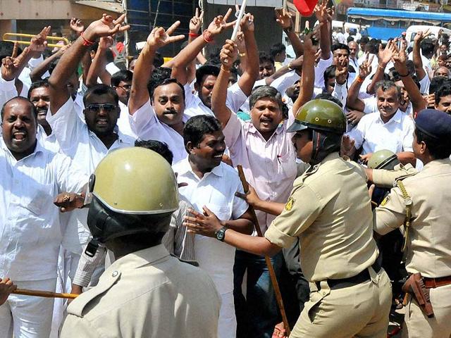 Security men push away supporters of J Jayalalithaa while she proceeds to the special court in Bangalore. (PTI photo)