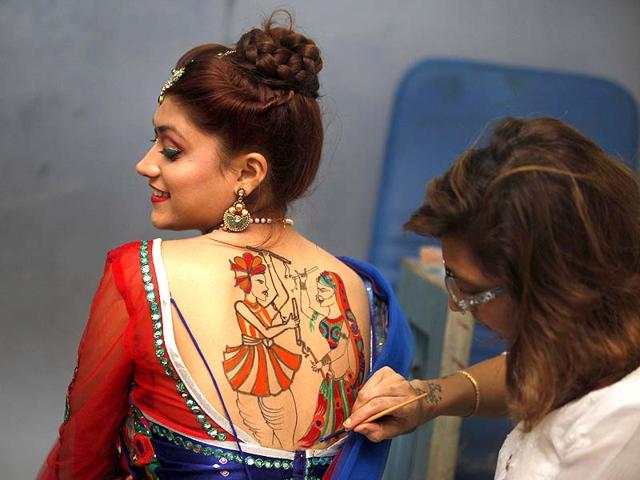 People get tattoos made during Navratri festival by a specialist at the Big Boss salon at Borivali, in Mumbai. (Vidya Subramanian/HT photo)