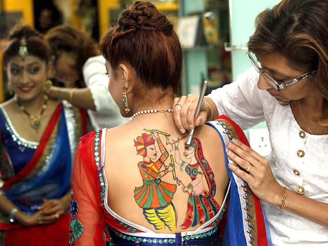 People get tattoos made during Navratri festival by a specialist at the Big Boss salon at Borivali, in Mumbai. (Vidya Subramanian/HT photo)