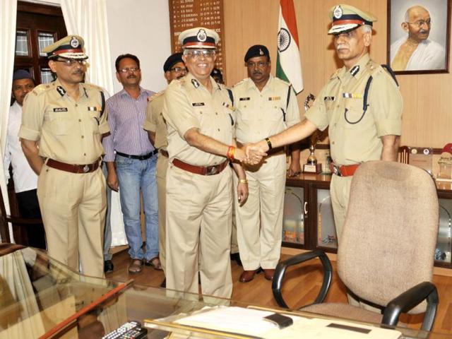 DGP Nandan Dube (left), who retired on Tuesday, hands over charge to newly appointed DGP Surendra Sinh at PHQ in Bhopal. (Praveen Bajpai/HT photo)