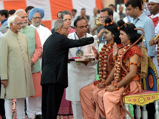 President Pranab Mukherjee applying 'Tilak' to artists, enacting Lord Ram and Laxman during Dussehra celebrations at Subhash Maidan in New Delhi. (PTI Photo)