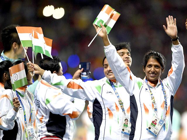Indian athletes Annu Rani and Narayana Sharadha wave national flags as they enter the arena during the closing ceremony. (AFP Photo)