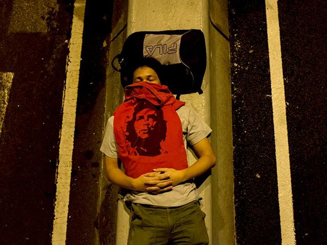 A protester sleeps on a road outside the Central Government Office in Hong Kong. (AFP Photo/Ed Jones)