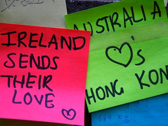 Messages of support for pro-democracy protesters in Hong Kong are written on bits of paper stuck to the outside of Hong Kong House in central Sydney. (Reuters Photo/David Gray)
